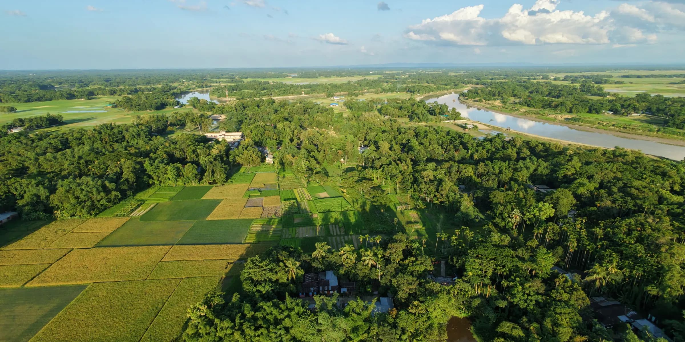 Aerial view of fields, villages and a river winding across the plains